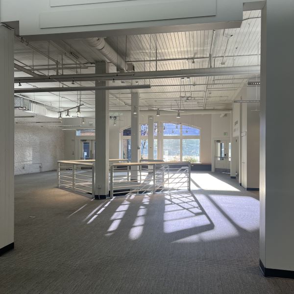 Empty retail space with large windows and staircase
